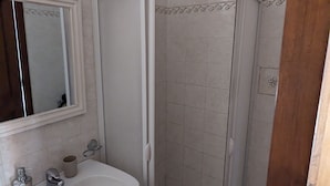 A bathroom with a white sink, mirror, and shower enclosure. - B&B Bellavista (Castro)
