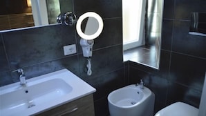 Moderni kylpyhuone, jossa on valkoinen pesuallas, bidee ja wc.