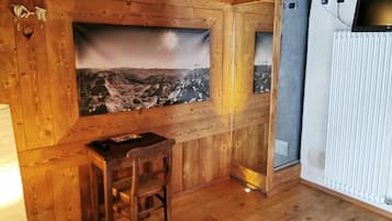 Une pièce de style cabane en bois, comprenant un bureau, une chaise et un grand tableau représentant un paysage de montagne.