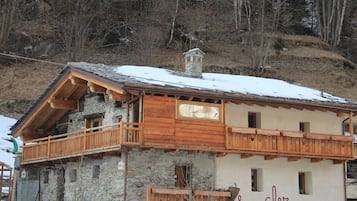 La Cluv offers a traditional chalet-style building with a stone facade and wooden balconies.