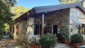 A stone building with a covered patio, potted plants, and outdoor seating. - Kamarca House Hotel (Ortaca)