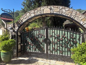 A stone archway with a metal gate featuring floral designs. - Kamarca House Hotel (Ortaca)
