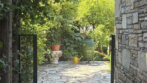 A stone pathway leading through a garden with potted plants and a stone wall. - Kamarca House Hotel (Ortaca)