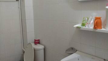 A bathroom with a toilet, sink, and a mirror above the sink.