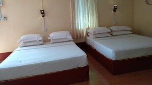 A hotel room with two single beds, a window with curtains, and a wall-mounted light fixture. - Galaxy Motel Hpa An (Hpa-An)
