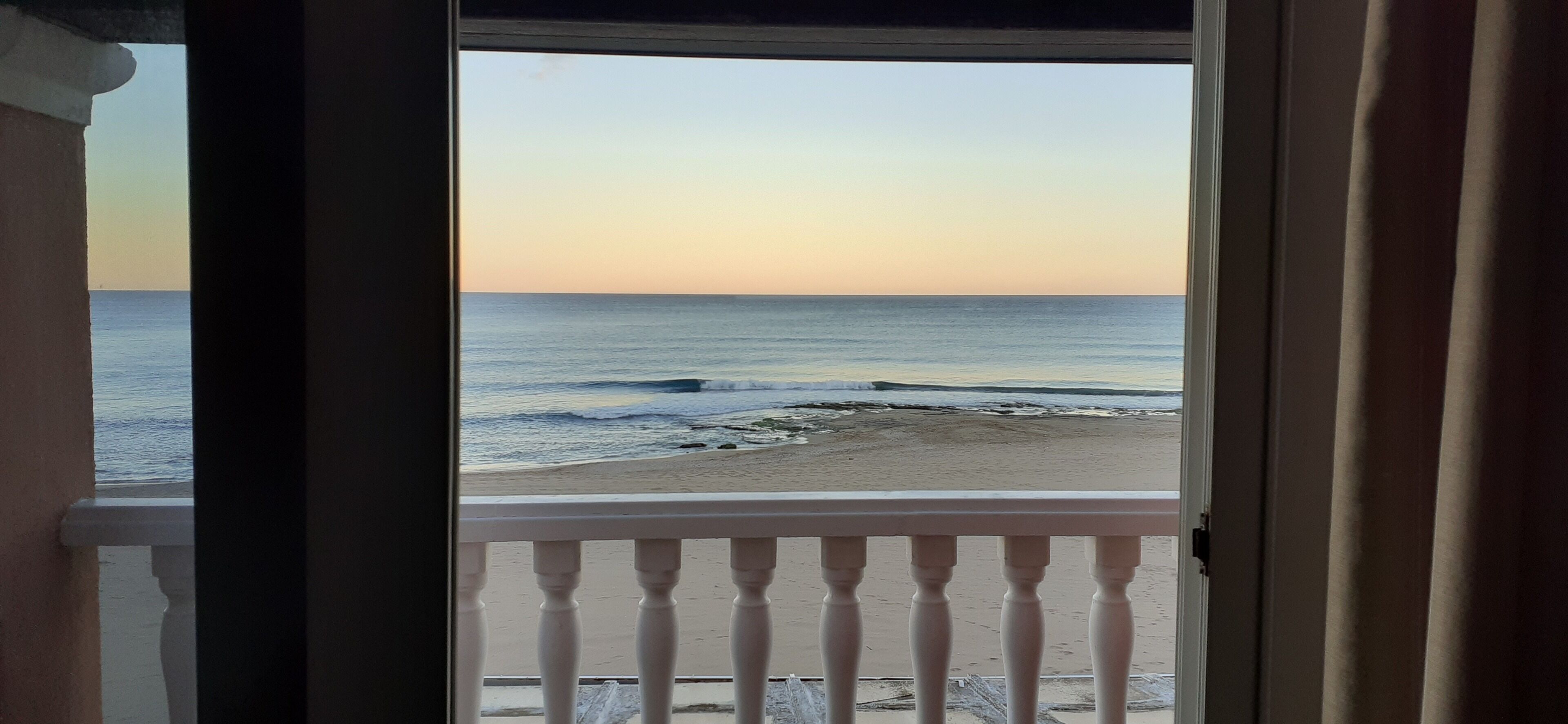 Vista de l'oceà des d'un balcó amb barana.