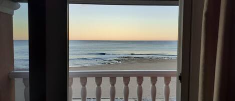 A view of the ocean from a balcony with a railing.
