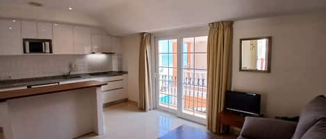A modern apartment with a kitchen, dining area, and living room.