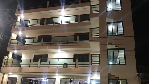 A multi-story building with balconies, large windows, and a ground-level entrance with glass doors. - Porto Palace Pousada (Ipojuca)