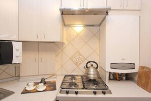 Economy kamer, 1 twee- of 2 eenpersoonsbedden, gedeelde badkamer | Privékitchenette | Een koelkast, een magnetron, een kookplaat, kookgerei, borden en bestek