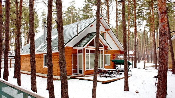 A cabin with a sloped roof, large windows, and a deck area. - Ekodom (Voropaiv)