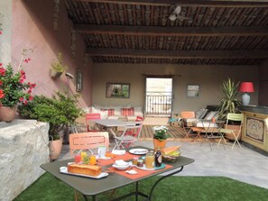 An outdoor patio with a table set for dining, chairs, and a seating area with cushions. - Eden Roque (La Roque-d'Antheron)