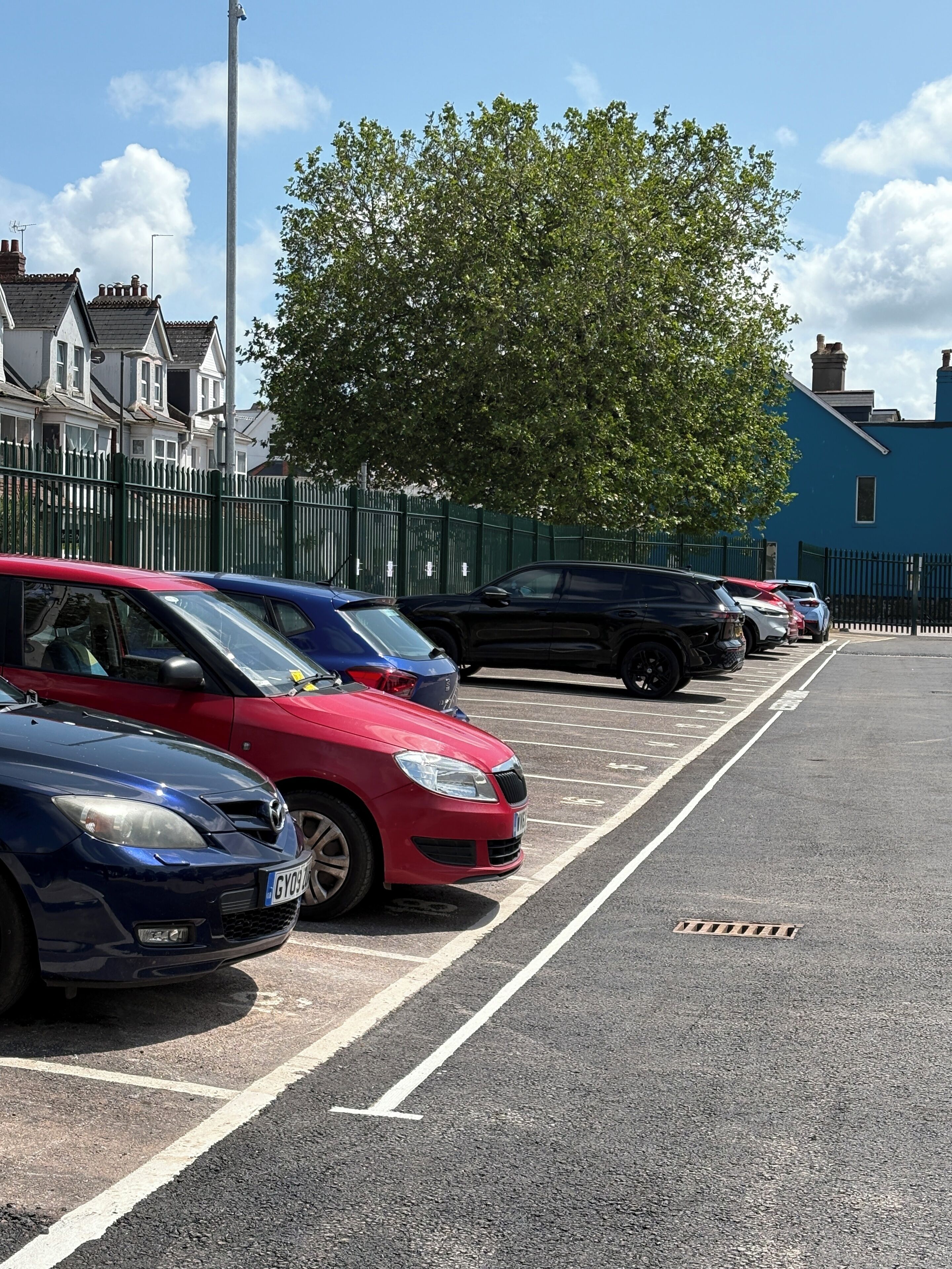 A parking lot with several cars parked in designated spaces.