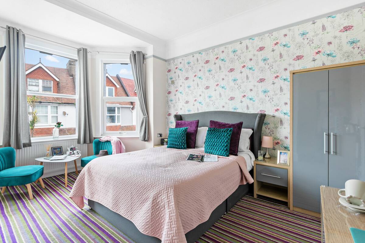 Une chambre d’hôtel comprenant un lit, une table de chevet, une chaise, un bureau et une armoire.