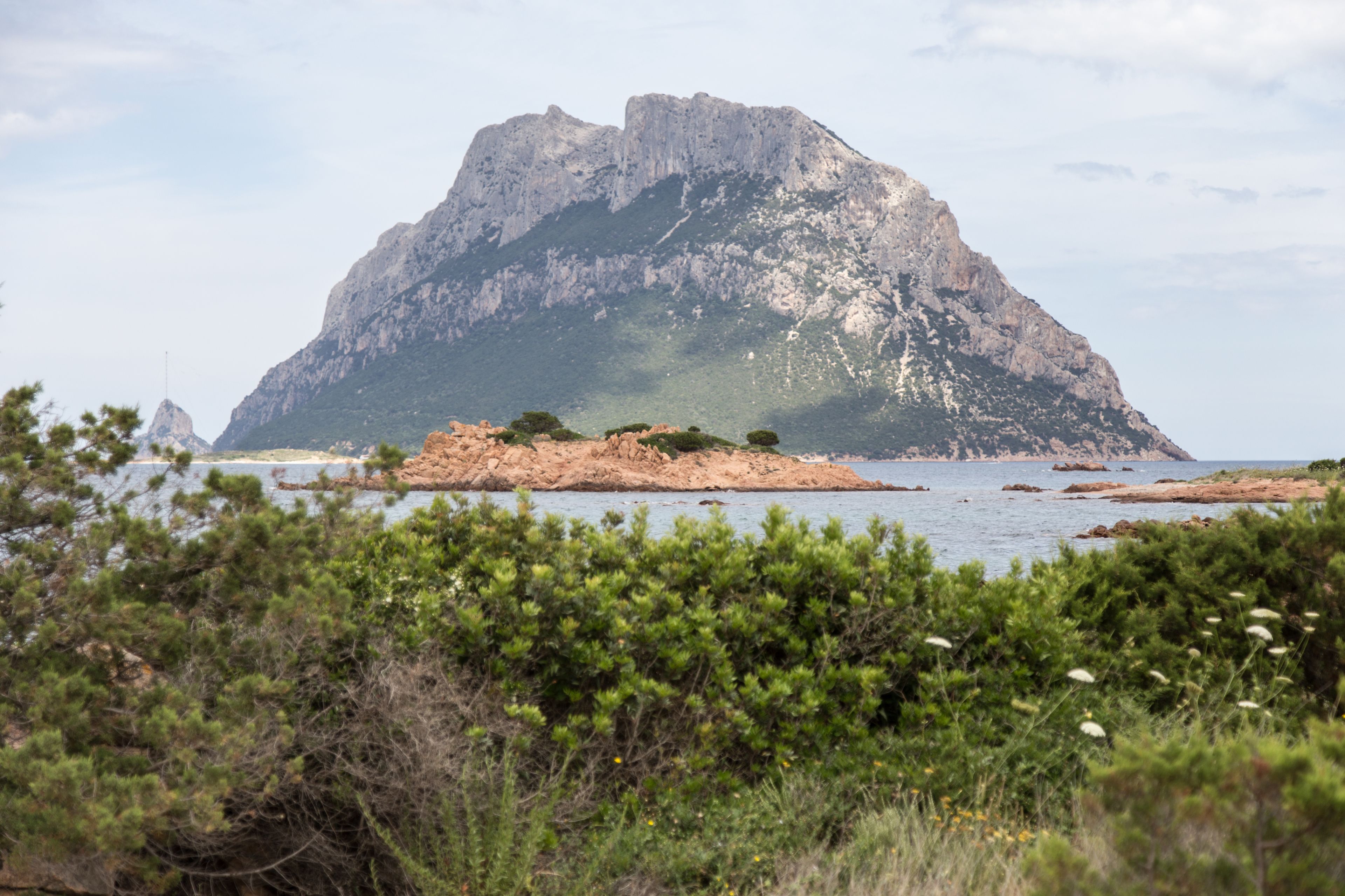 A mountainous landscape with a rocky outcrop in the foreground and a large mountain in the background.