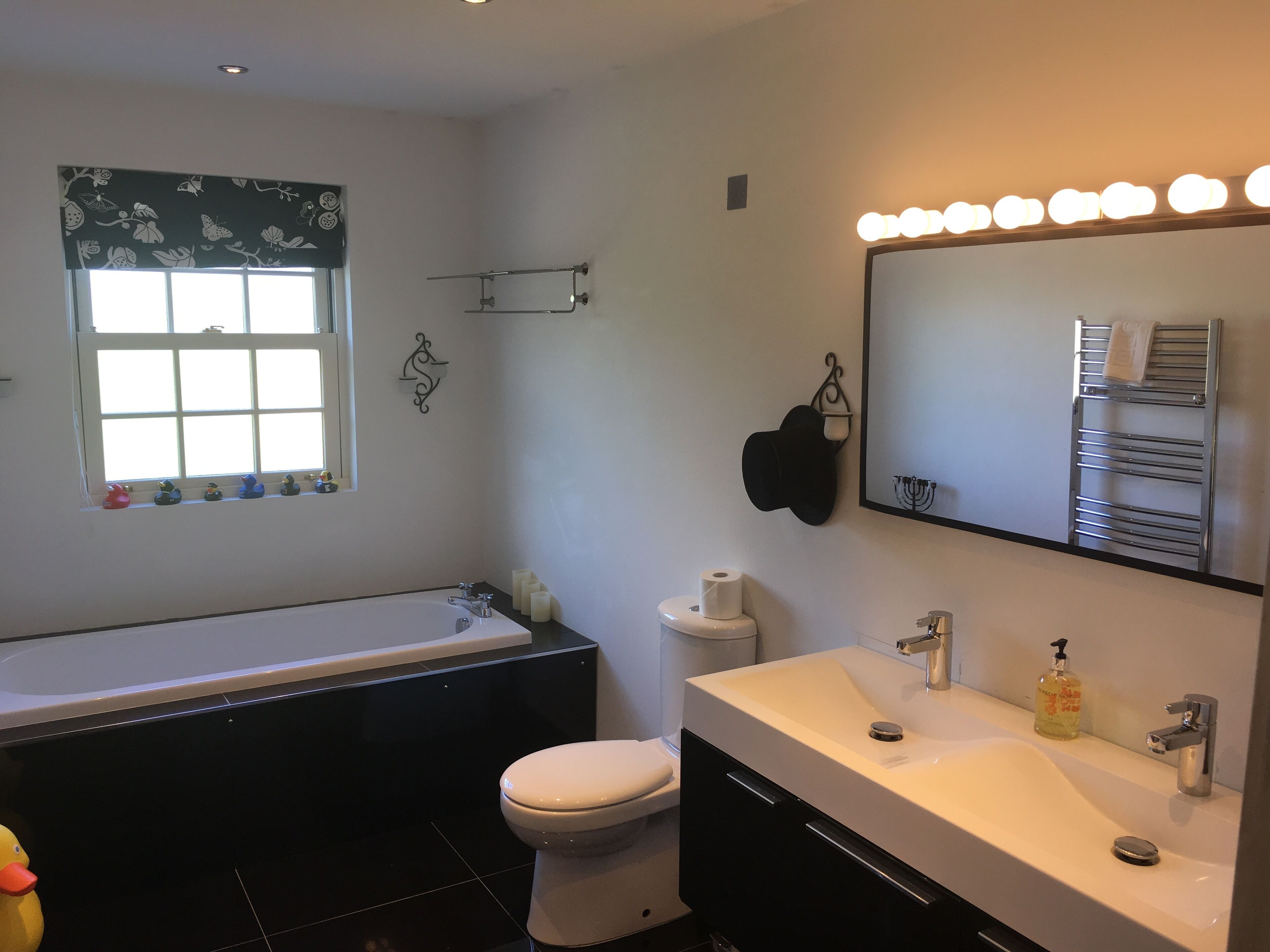 A modern bathroom with a bathtub, toilet, and vanity.