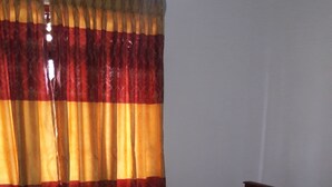 A neatly made bed with white linens, a wooden headboard, and two decorative pillows. - Hotel Blue Moon (Dambulla)