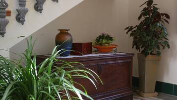 Une commode en bois, ornée de vases décoratifs et d’une plante en pot.
