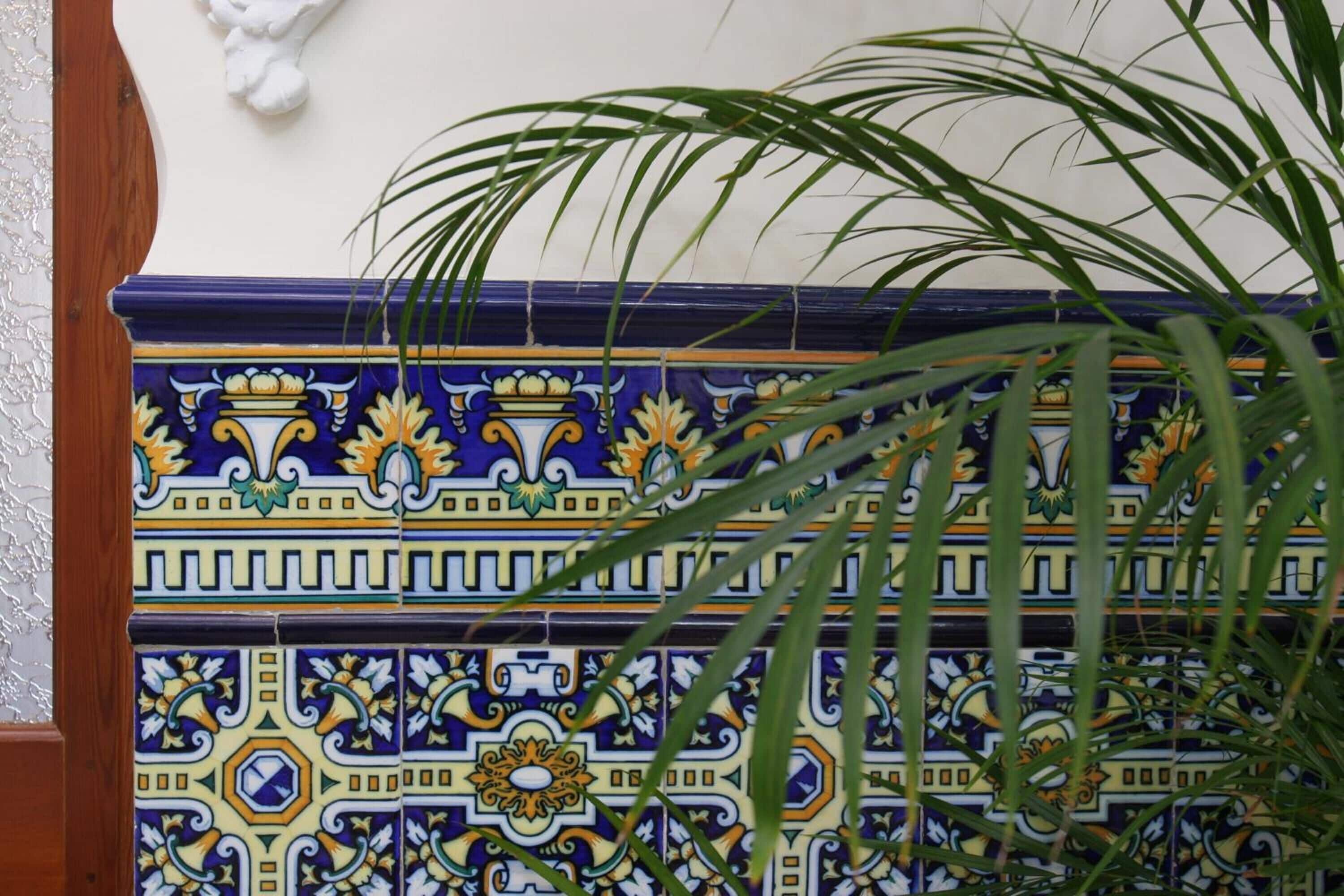 A section of a wall with decorative tiles featuring geometric and floral patterns.
