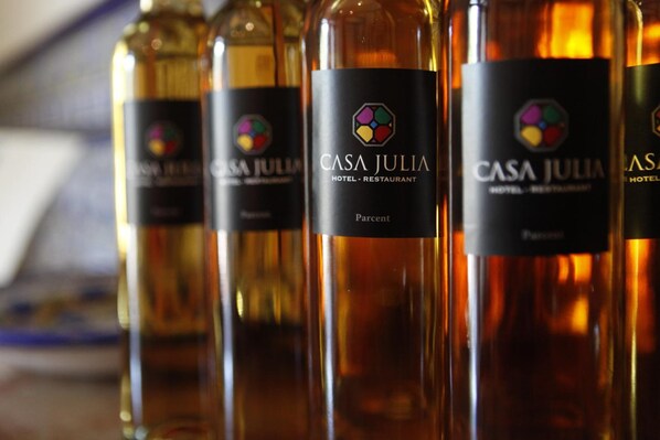 Una fila de botellas con etiquetas que dicen "Casa Julia Hotel - Restaurant".