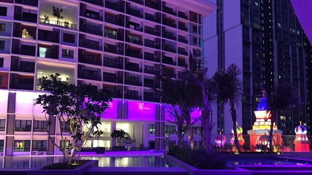 Un hôtel moderne à plusieurs étages, doté d’un espace piscine et d’un bâtiment aux couleurs vives, agrémenté de décorations originales.
