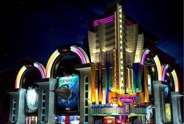 A brightly lit building with neon signs and arches, including a prominent 'Adventure' sign.