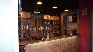 A bar area with a wooden counter, shelves stocked with various bottles and glasses, and a sign indicating 'Heineken' and 'Gold Drinks Here'. - Euphoria Inn (Tbilisi)