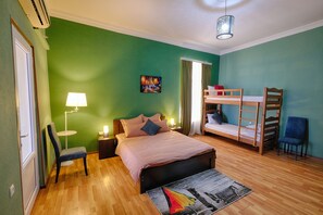 Una camera da letto con un letto, una sedia, una scrivania, una lampada, un letto a castello e un quadro appeso al muro.