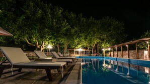 Zona de piscina con sillones de descanso y una alberca.