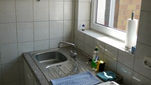 A small kitchen with a sink, a window, and a mirror. - SleepInHamburg St.Pauli Apartment 35&36 (Hamburg)