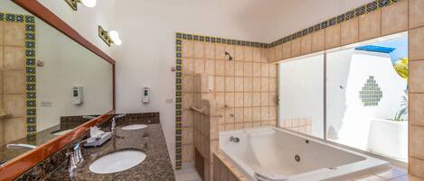 A bathroom with two sinks, a large bathtub, and a shower.