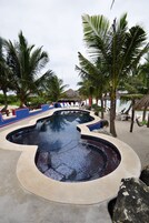 Una piscina al aire libre, sillones reclinables de piscina