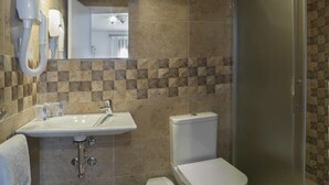 Un baño con lavamanos, inodoro y ducha.