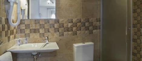 A bathroom with a sink, toilet, and shower.