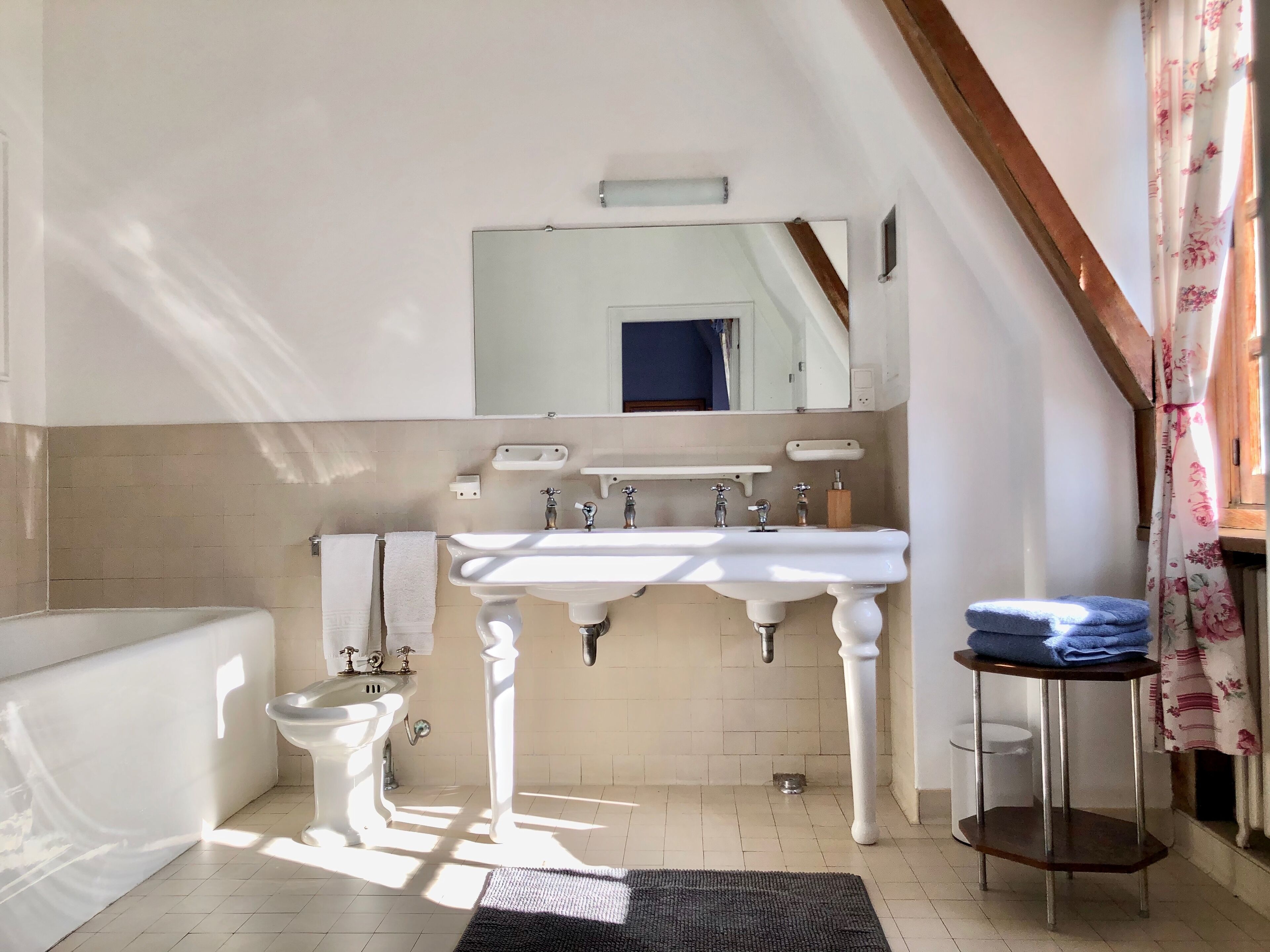A bathroom with a white sink, a mirror, a toilet, and a bathtub.