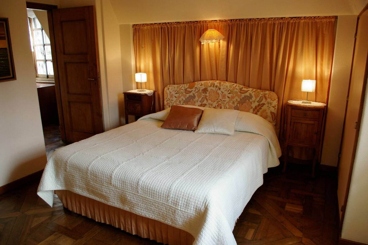 Ein Hotelzimmer mit einem großen Bett, zwei Nachttischen und einem Kopfteil mit Blumenmuster.