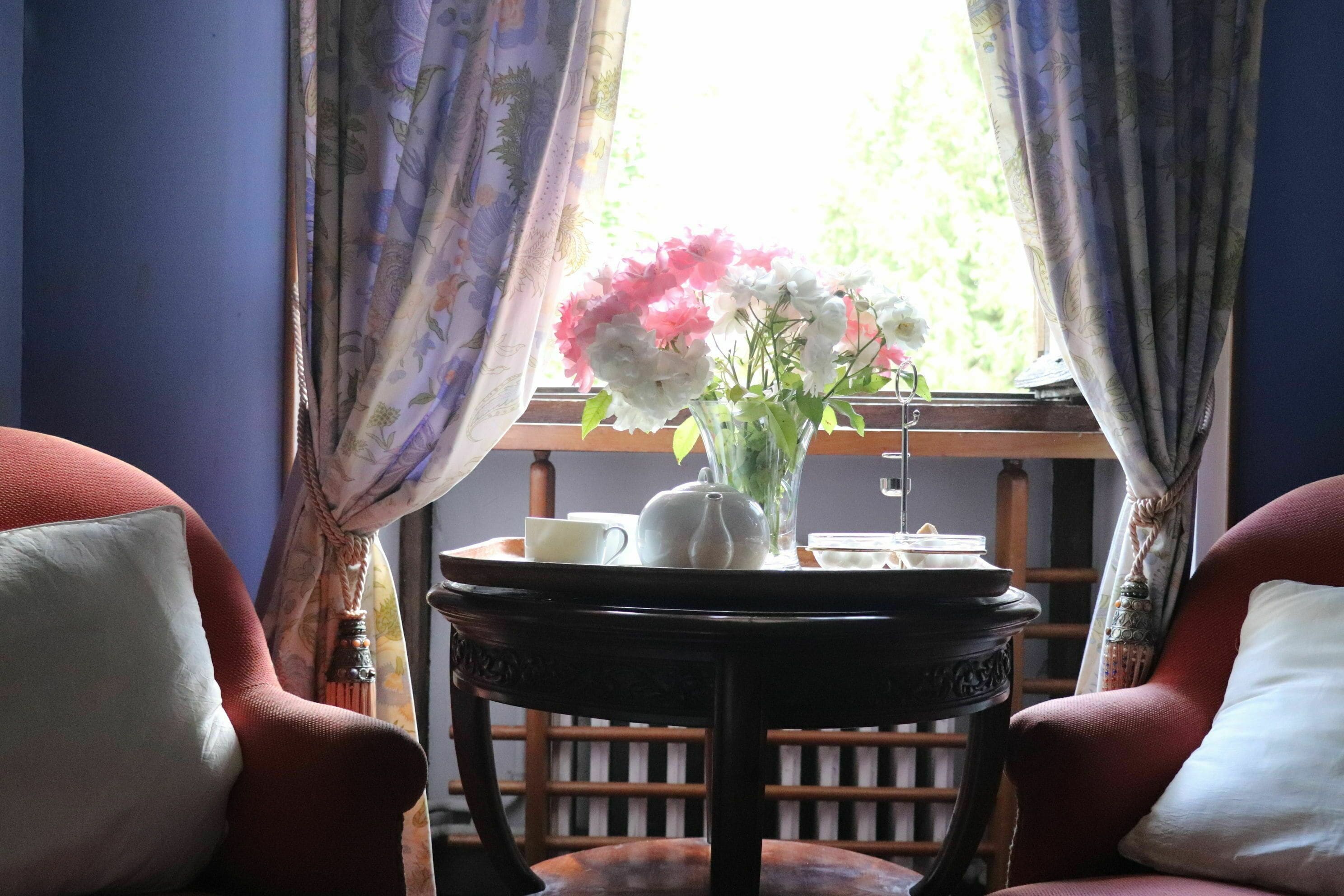 Une pièce où une table est dressée pour le thé, avec une théière, une tasse et une soucoupe.