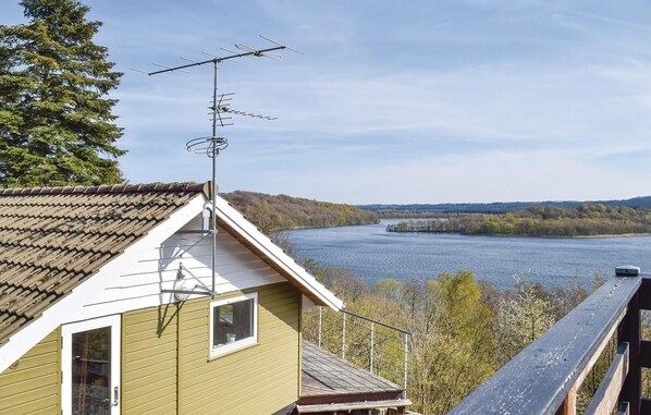 Situated by the river, this building offers a view of the surrounding forest and water from its wooden deck.