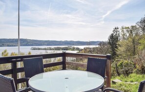 Sit and enjoy the serene lake view from this outdoor seating area with a round table and two comfortable chairs.