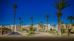 Ein Resort mit mehrstöckigen Gebäuden, Palmen und blauem Himmel.