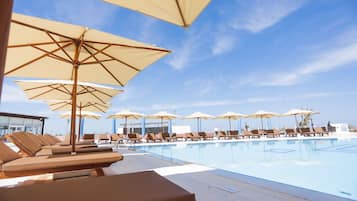 Piscine couverte, piscine extérieure, parasols de plage, chaises longues