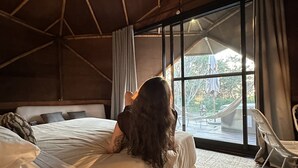Quarto com uma cama grande, janela e vista para o exterior.