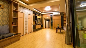 A modern kitchen with wooden cabinets, a built-in oven, and a dining area with a table and chairs. - GetZleep House Sattahip (Sattahip)