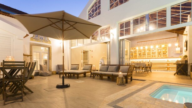 A spacious outdoor area with a pool, seating arrangements, and a bar area. - Ericeira Soul (Mafra)
