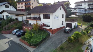 A two-story house with a sloped roof, a balcony, and a garage.