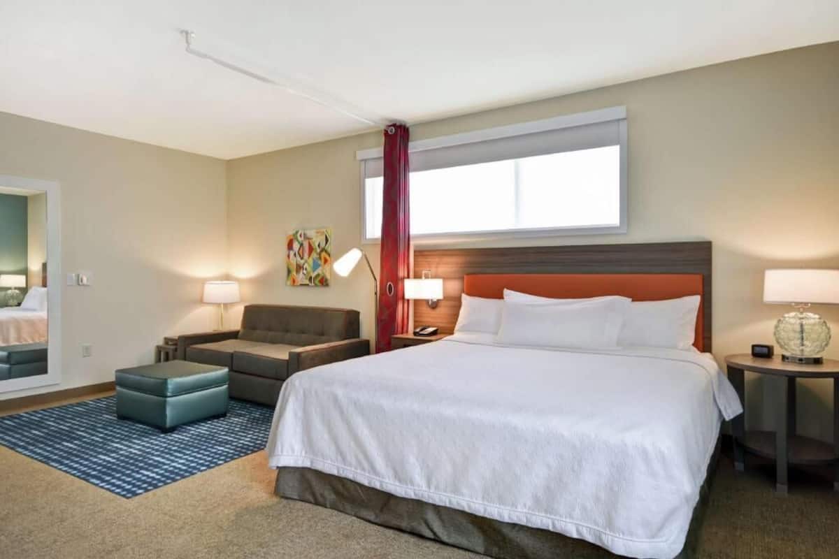 Een hotelkamer met een groot bed, een bank, een tafeltje en een bureau.