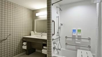 A modern bathroom with a shower, a sink, and a mirror.