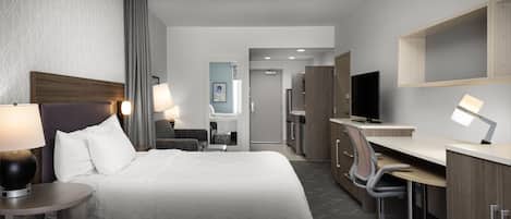 Ett hotellrum med två sängar, ett skrivbord, en stol och en tv. I bakgrunden syns badrummet.