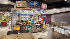 Un restaurant moderne doté d’un comptoir central, proposant une variété de plats et diffusant les actualités sur un écran de télévision.