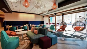 Un espace de détente moderne comprenant un canapé, des fauteuils et des fauteuils suspendus en forme d’œuf.